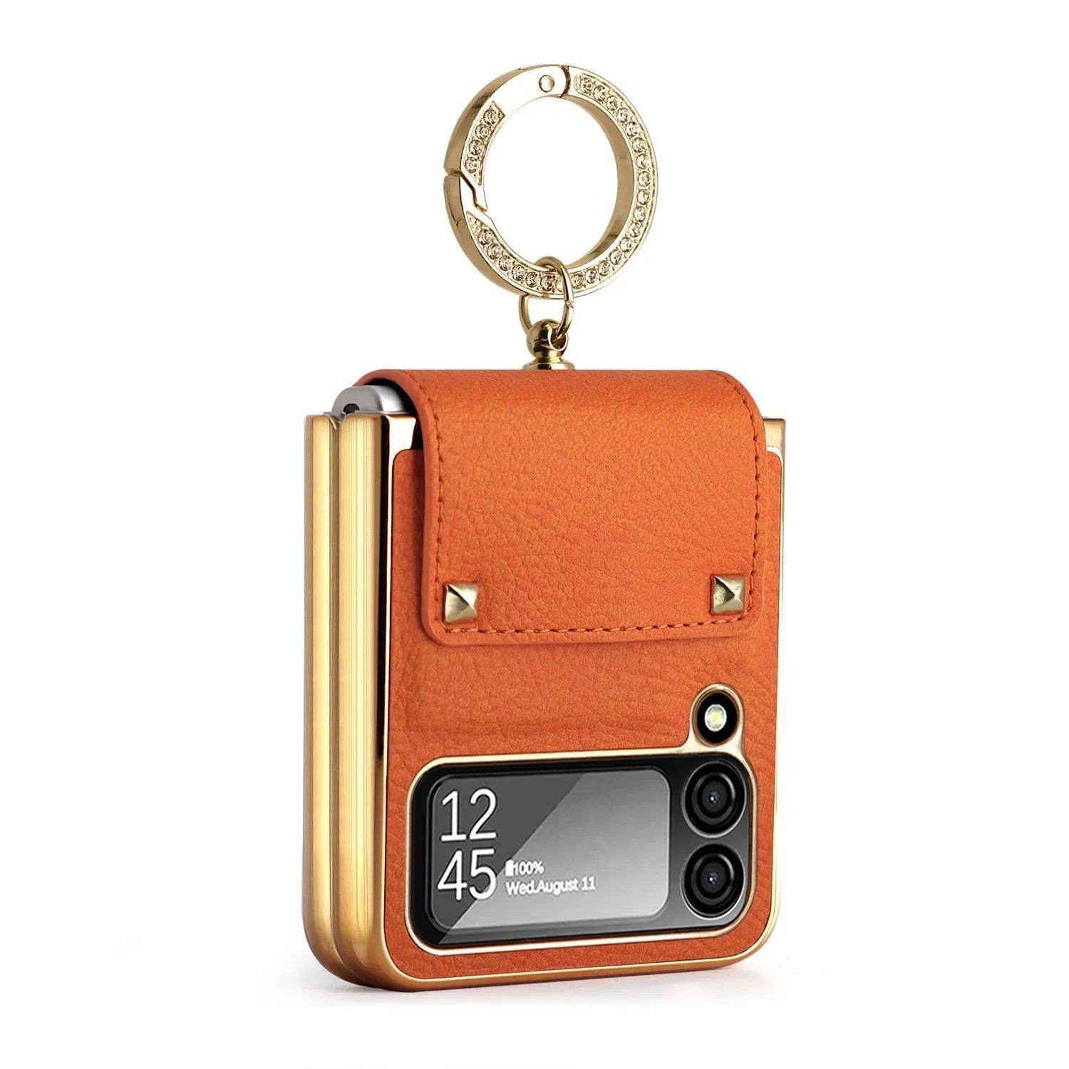 Foldable smartphone with brown leather protective cover and gold-tone rhinestone keyring
