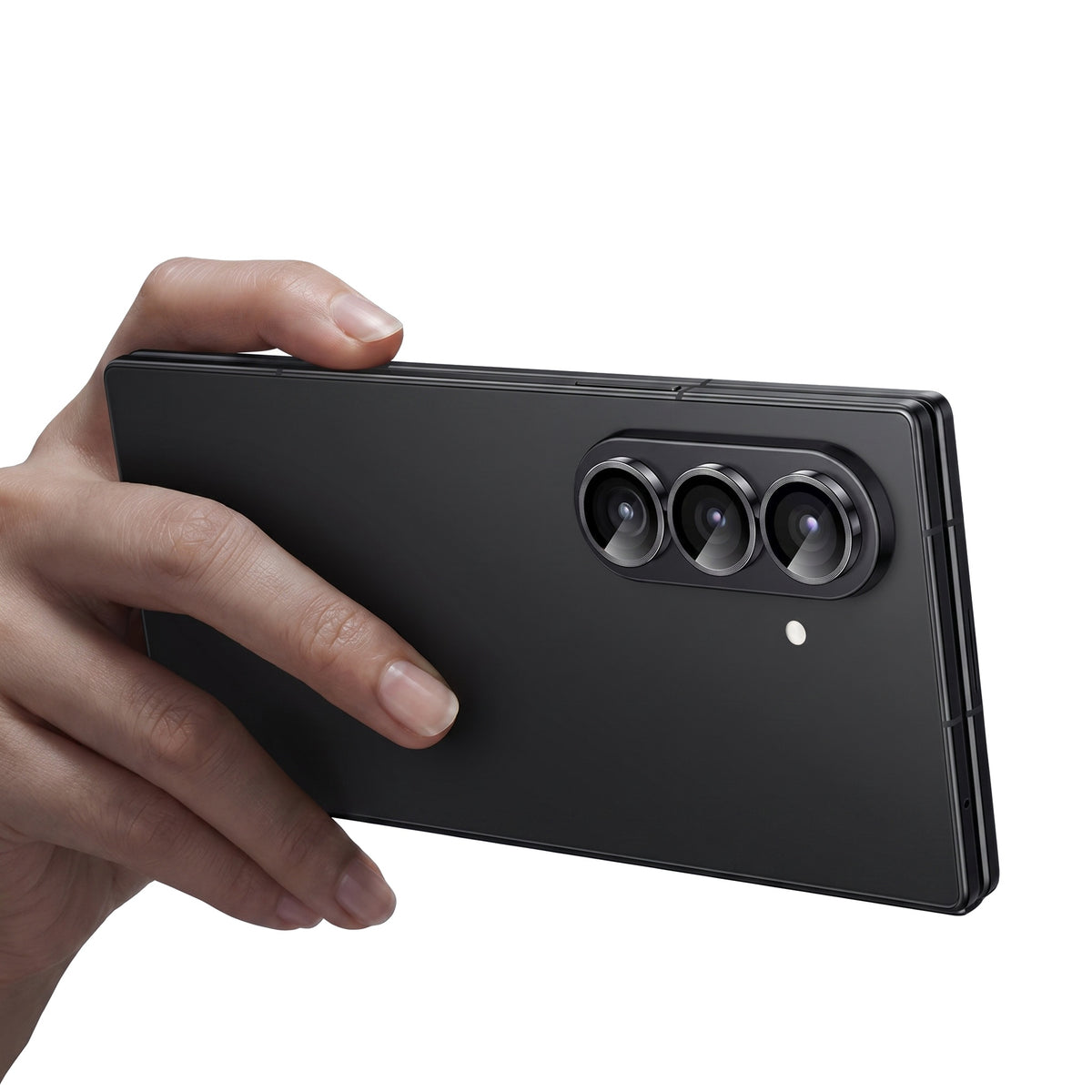 Hand holding a folded Galaxy Z Fold showing the three tempered glass camera lens protector rings installed on the camera module